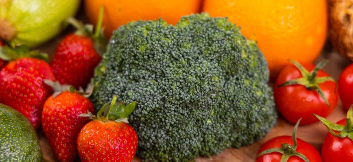 A vibrant collection of fresh, organic fruits and vegetables on a wooden table, showcasing healthy variety.